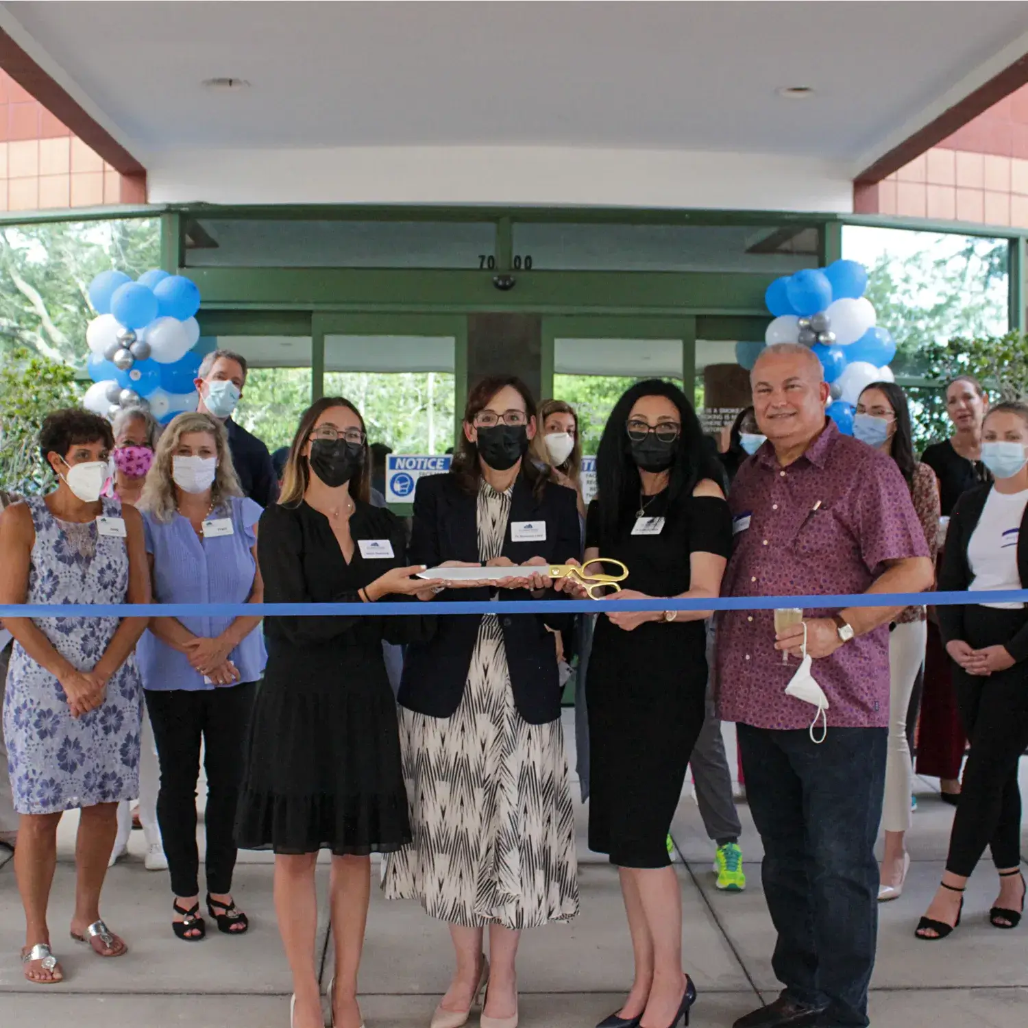 A group of smiling employees from the Viera office posing together outdoors.