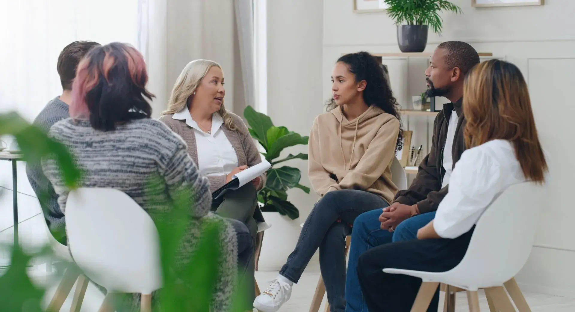 A group of people engaged in a lively conversation, gesturing and smiling.